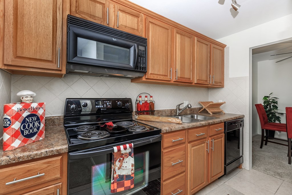 a kitchen with wooden cabinets and black appliances