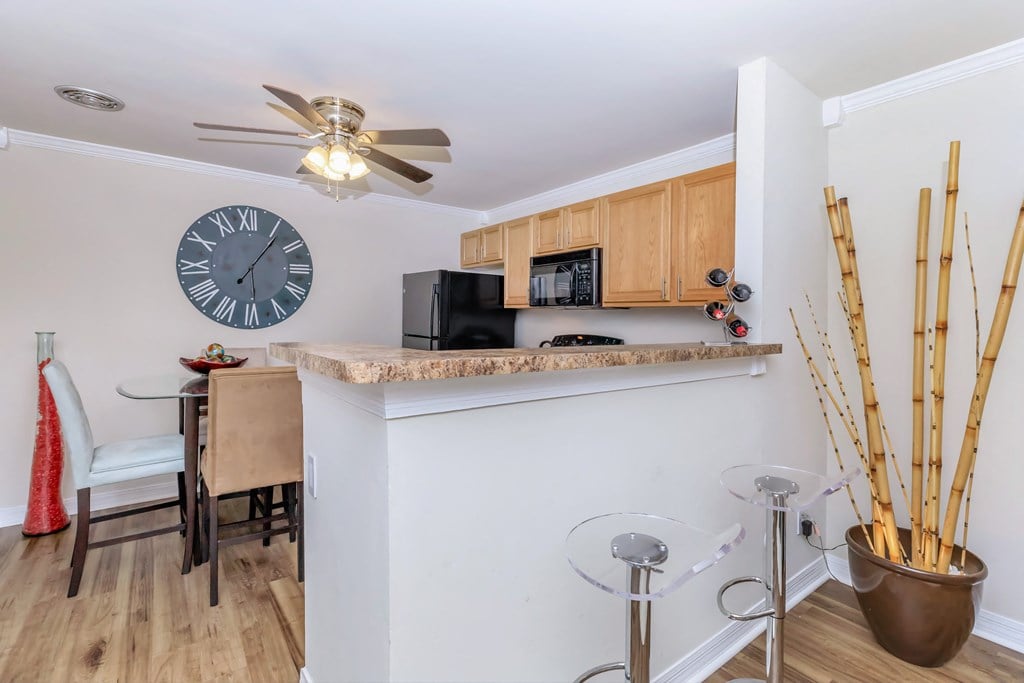a kitchen and dining area with a large clock on the wall