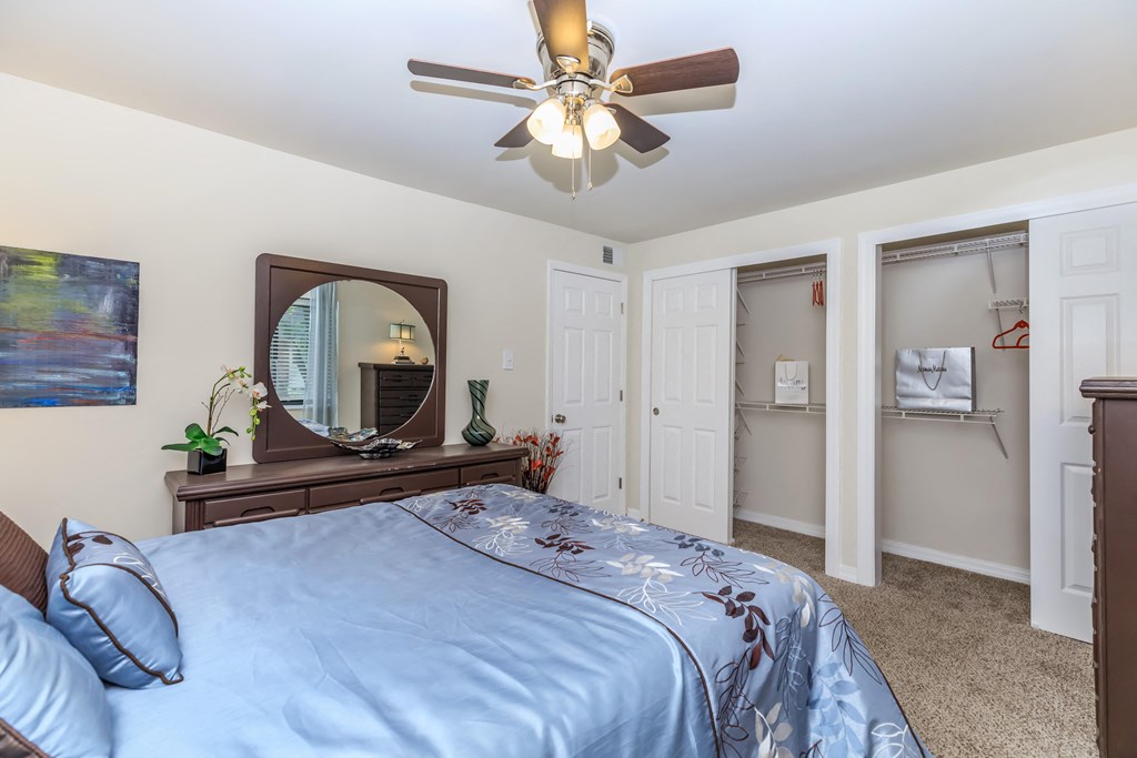 a bedroom with a large bed and a ceiling fan
