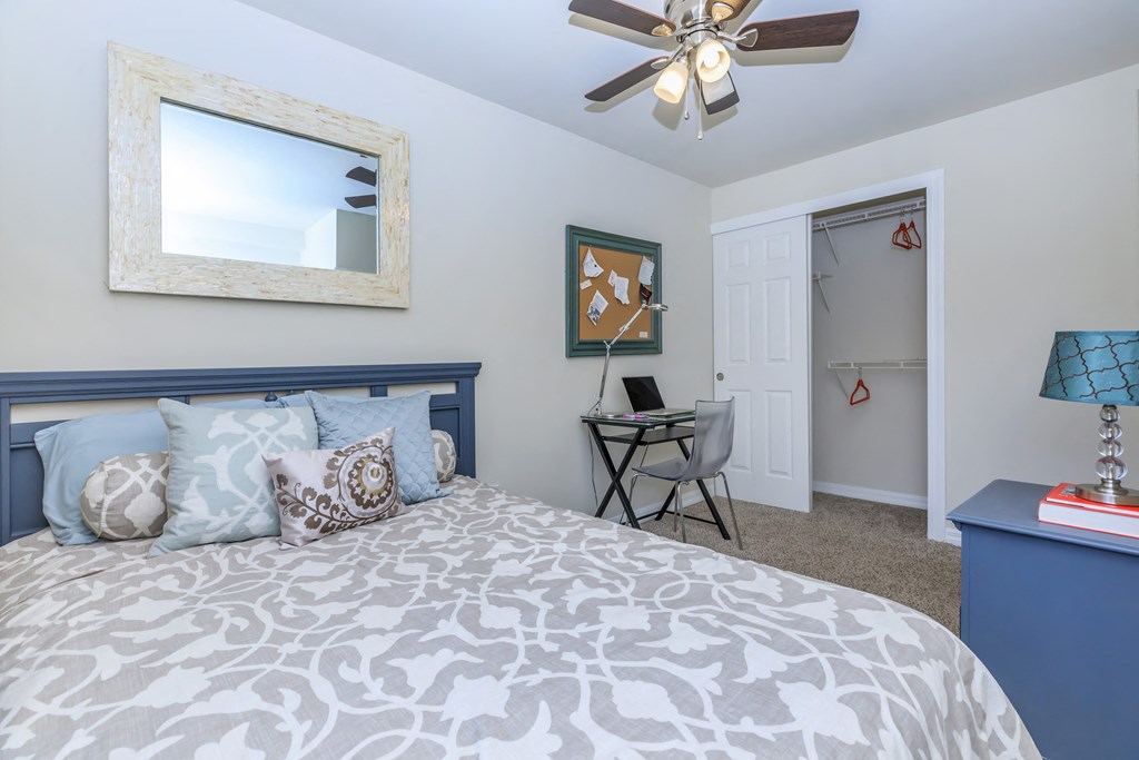 a bedroom with a bed and a ceiling fan