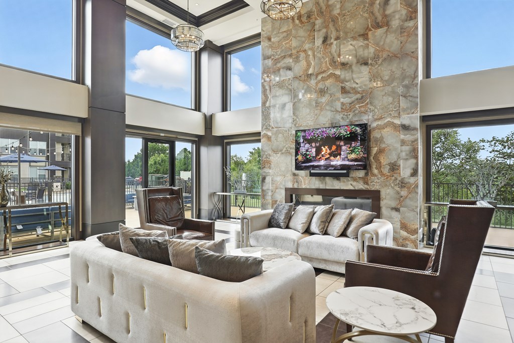 A modern living room with a stone pillar and a flat screen TV mounted on it at Alinea Town and Country Luxury Apartments in Des Peres MO 63131..