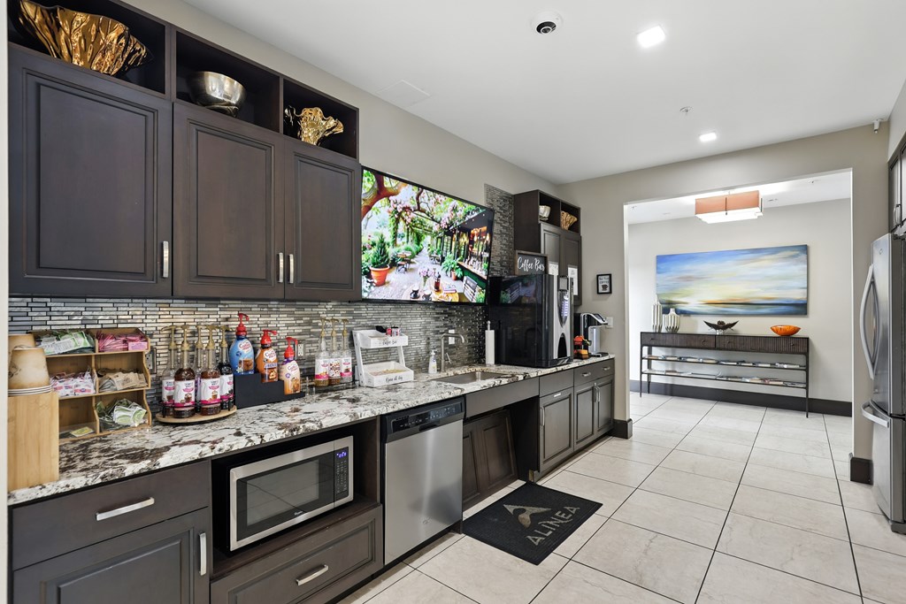 A kitchen with dark brown cabinets and a white counter top at Alinea Town and Country Luxury Apartments in Des Peres MO 63131.