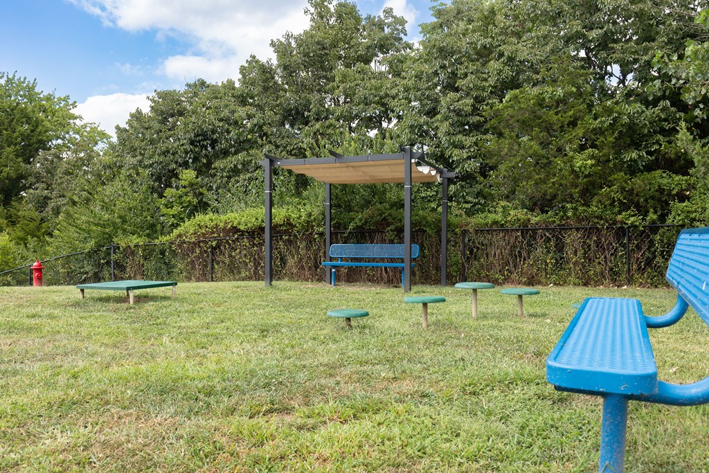 A park with a blue bench and picnic table at Alinea Town and Country Luxury Apartments in Des Peres MO 63131.