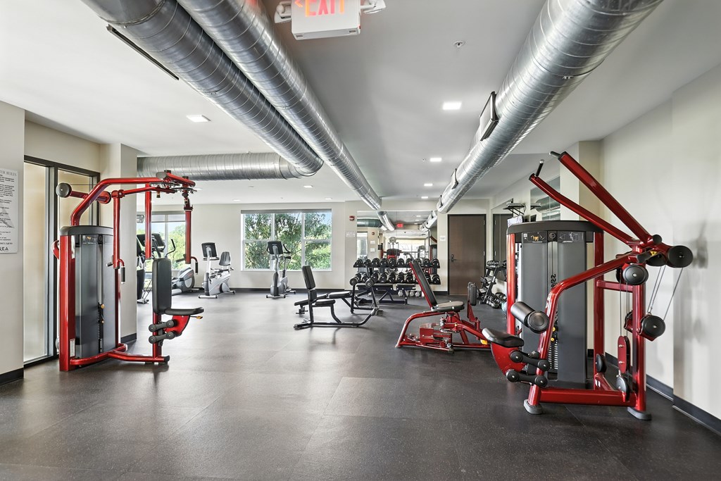 A gym with a variety of equipment including a leg press machine at Alinea Town and Country Luxury Apartments in Des Peres MO 63131.