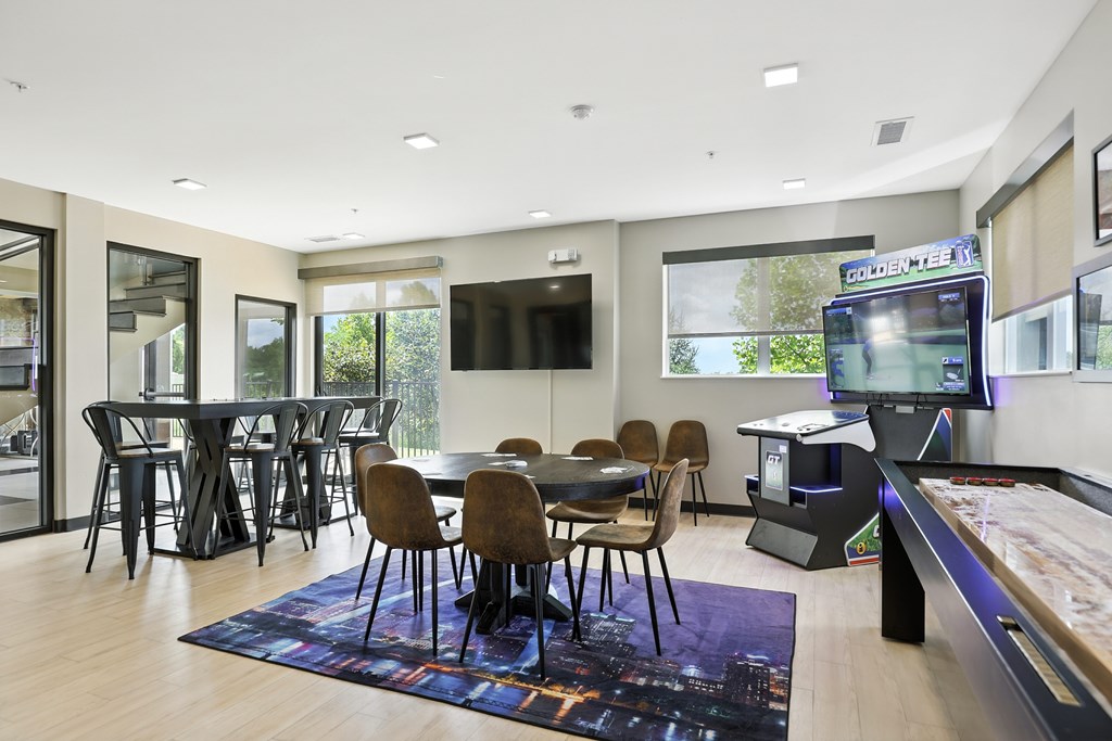 A modern room with shuffleboard, poker, golden tee, and workspace  at Alinea Town and Country Luxury Apartments in Des Peres MO 63131.