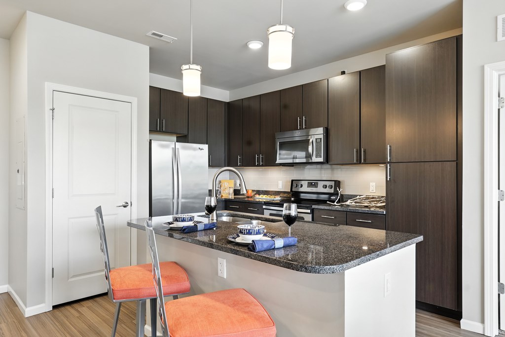 A kitchen with a white counter top and a refrigerator at Alinea Town and Country Luxury Apartments in Des Peres MO 63131.