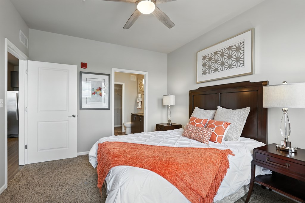 A bedroom with a bed, nightstand, and a ceiling fan at Alinea Town and Country Luxury Apartments in Des Peres MO 63131..