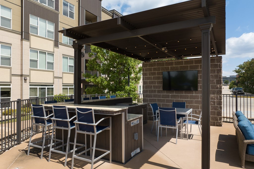 A patio with a table and chairs under a roof at Alinea Town and Country Luxury Apartments in Des Peres MO 63131..