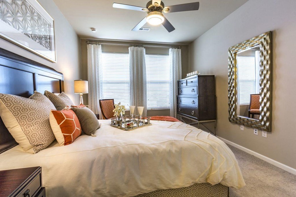 a bedroom with a large bed and a ceiling fan