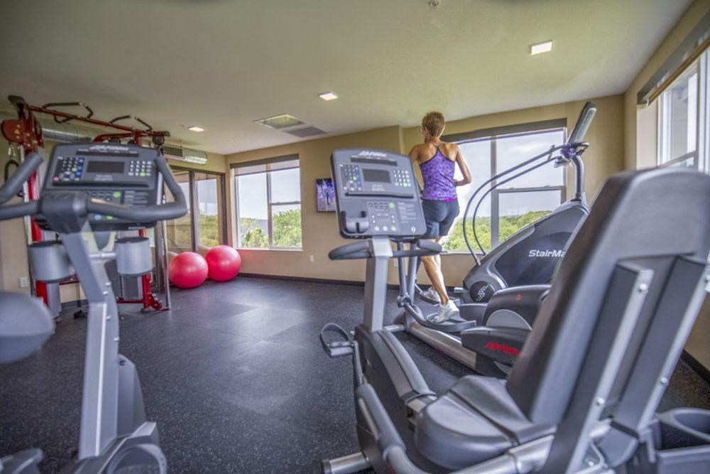 Alinea-Fitness-Center-01-Des-Peres-MO.jpeg a woman running on a treadmill in a gym