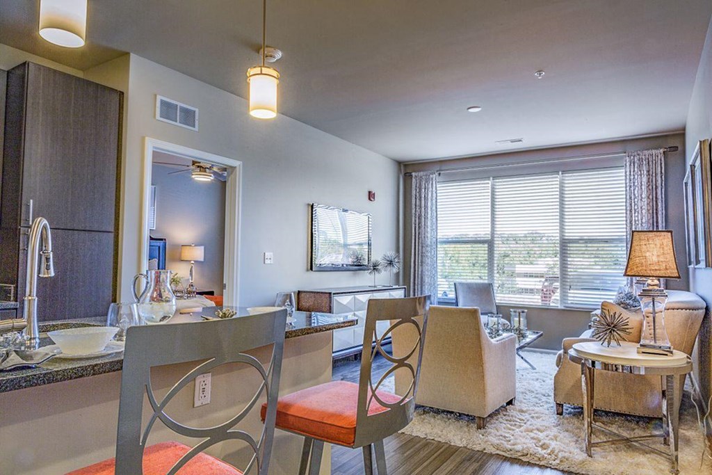 a living room and dining room with a table and chairs