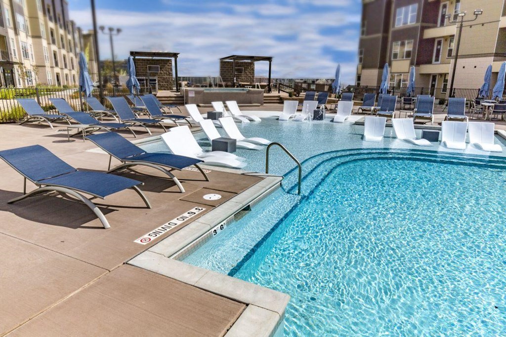 a swimming pool with blue and white chairs