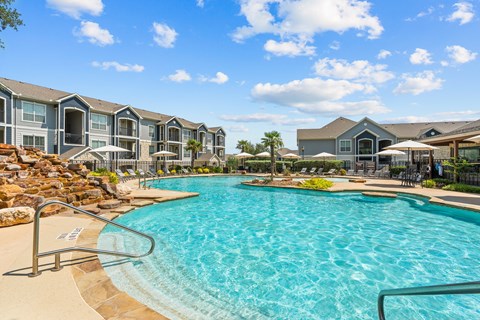 A large swimming pool in front of a resort-style building.