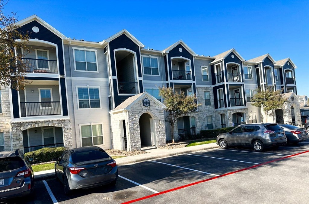 an apartment building with cars parked in front of it