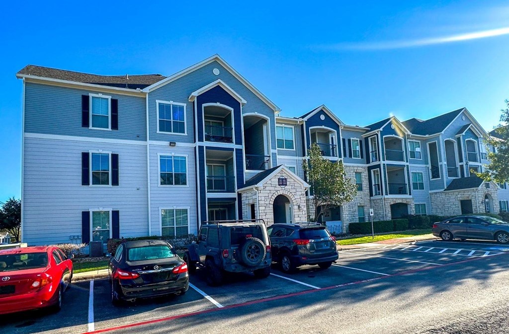 an apartment building with cars parked in front of it