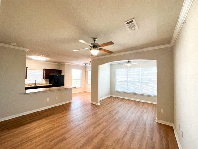 an empty living room with a ceiling fan