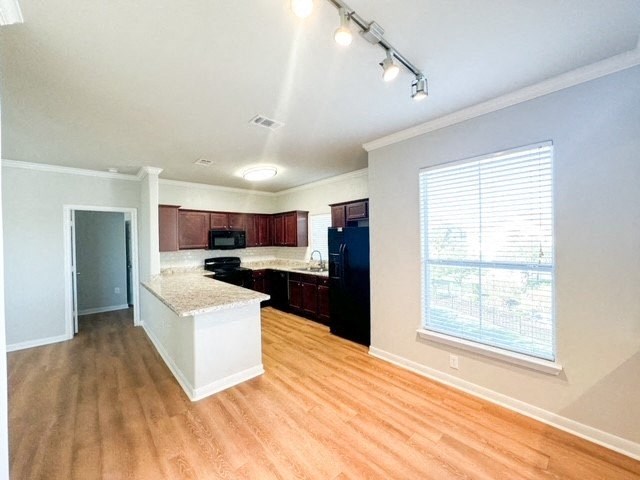 an empty kitchen with wood floors and a large window