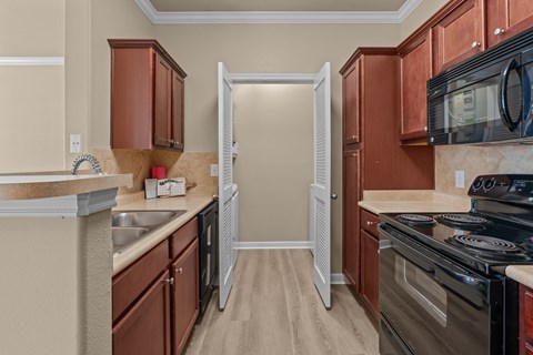 A kitchen with brown cabinets and a black stove top oven.