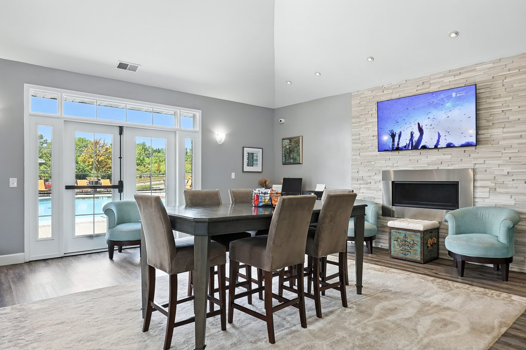 A modern dining room with a large table and chairs at Bramblett Hills Luxury Apartments in O Fallon MO 63366