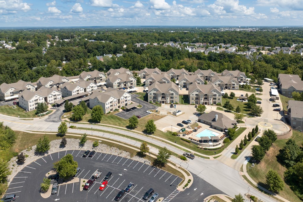 A large residential complex with a roundabout in the foreground at Bramblett Hills Luxury Apartments in O Fallon MO 63366