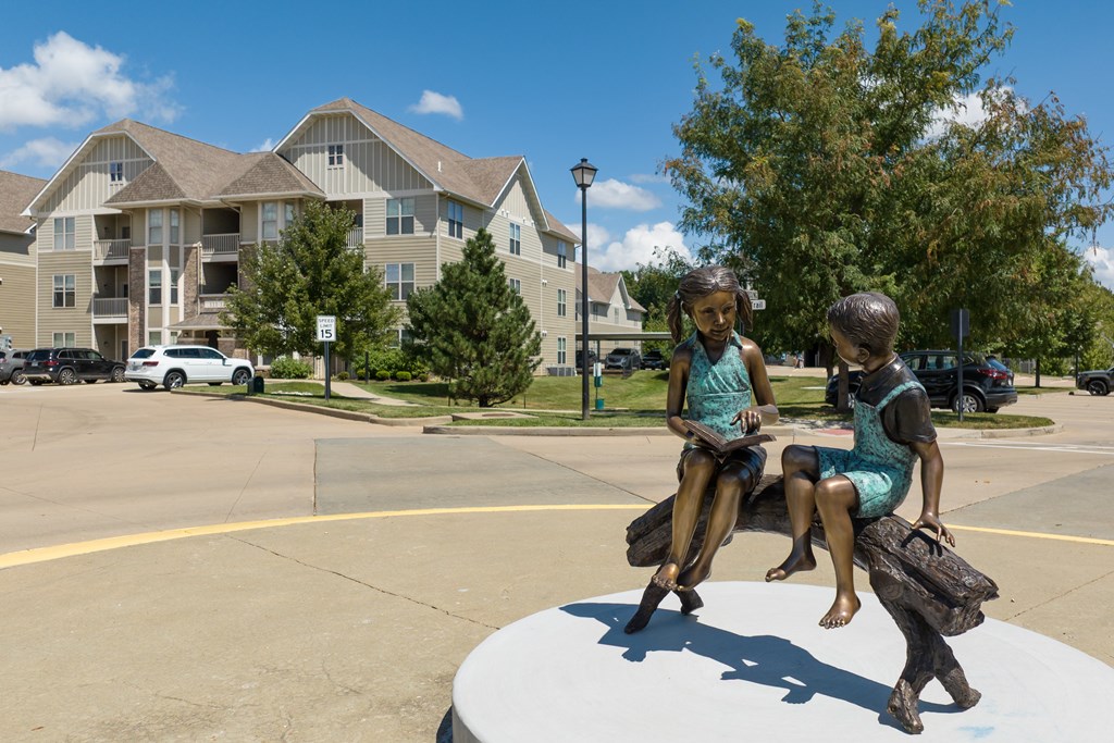 A statue of two children sitting on a bench at Bramblett Hills Luxury Apartments in O Fallon MO 63366