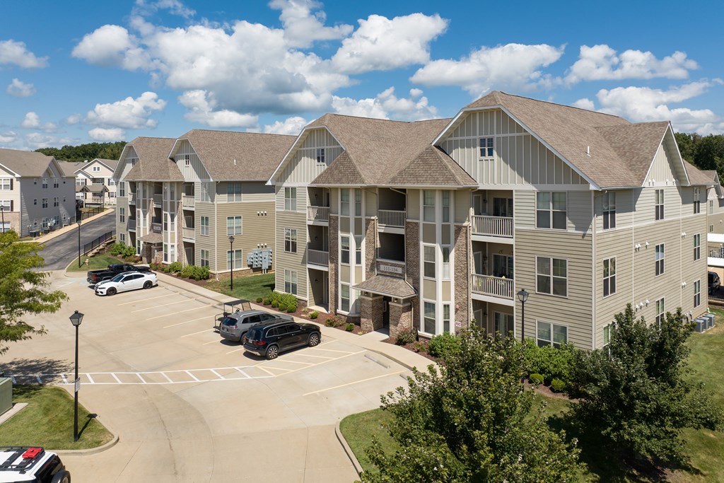 A large apartment complex with a parking lot in front at Bramblett Hills Luxury Apartments in O Fallon MO 63366