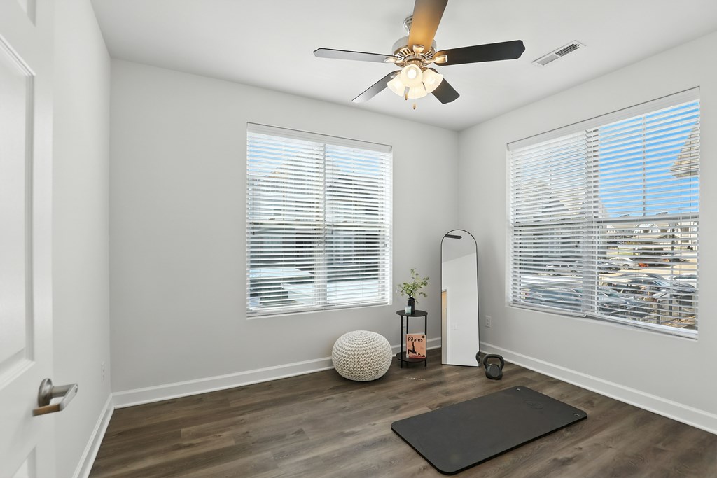 A room with a ceiling fan and a yoga mat on the floor at Bramblett Hills Luxury Apartments in O Fallon MO 63366