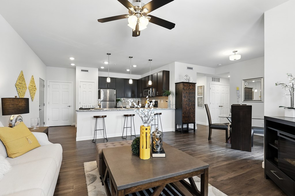 A modern kitchen with a white couch and a wooden table at Bramblett Hills Luxury Apartments in O Fallon MO 63366