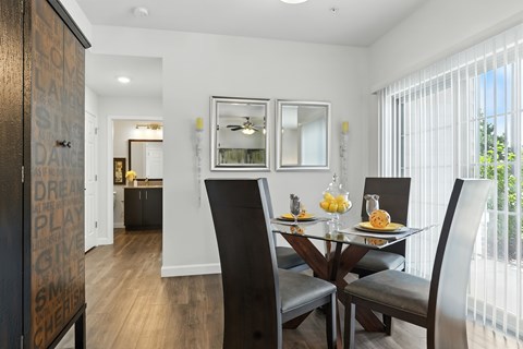 A dining room with a glass table and chairs.