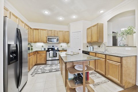 A kitchen with wooden cabinets and a refrigerator.