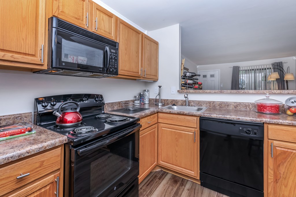 a kitchen with wood cabinets and black appliances