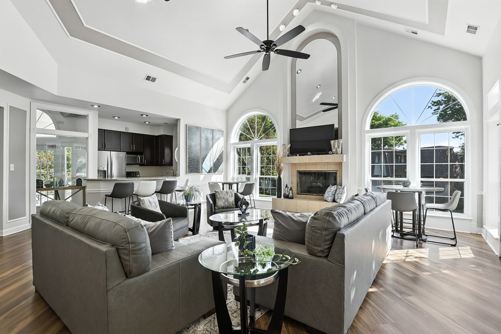 A modern living room with a grey sofa set and a glass coffee table.