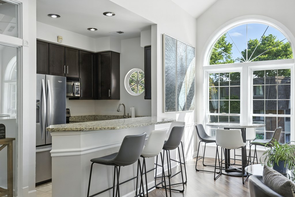 A kitchen with a bar area and a dining table.