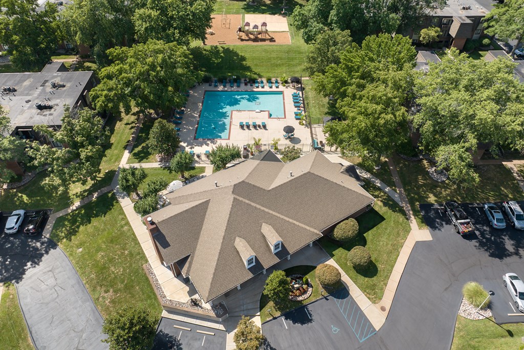 A bird's eye view of a house with a pool and trees.