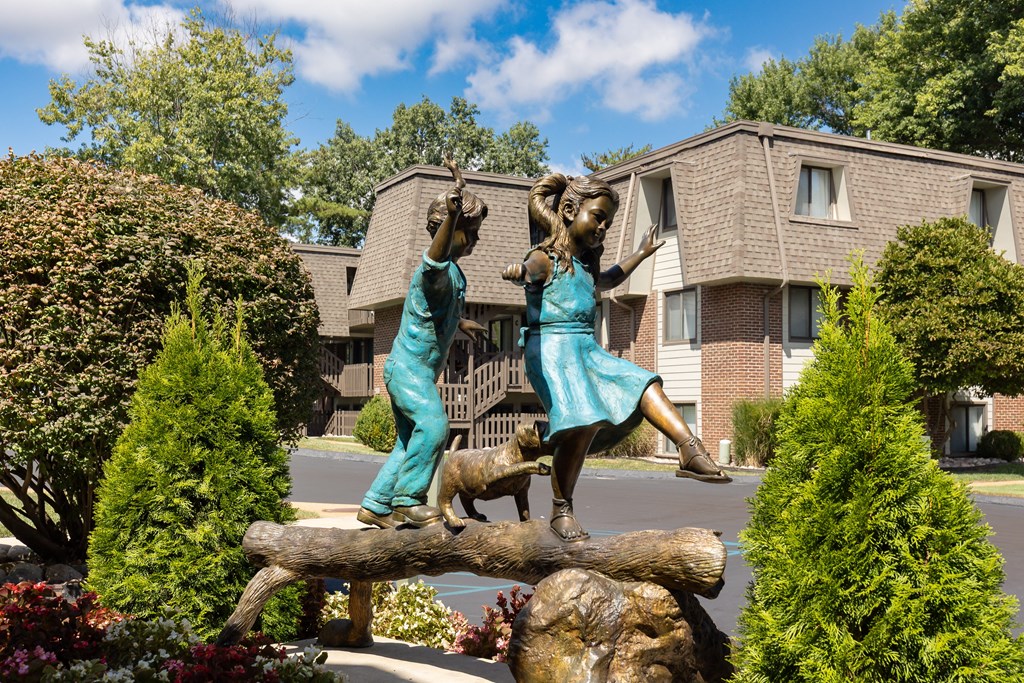 A statue of two people on a log in front of a building.