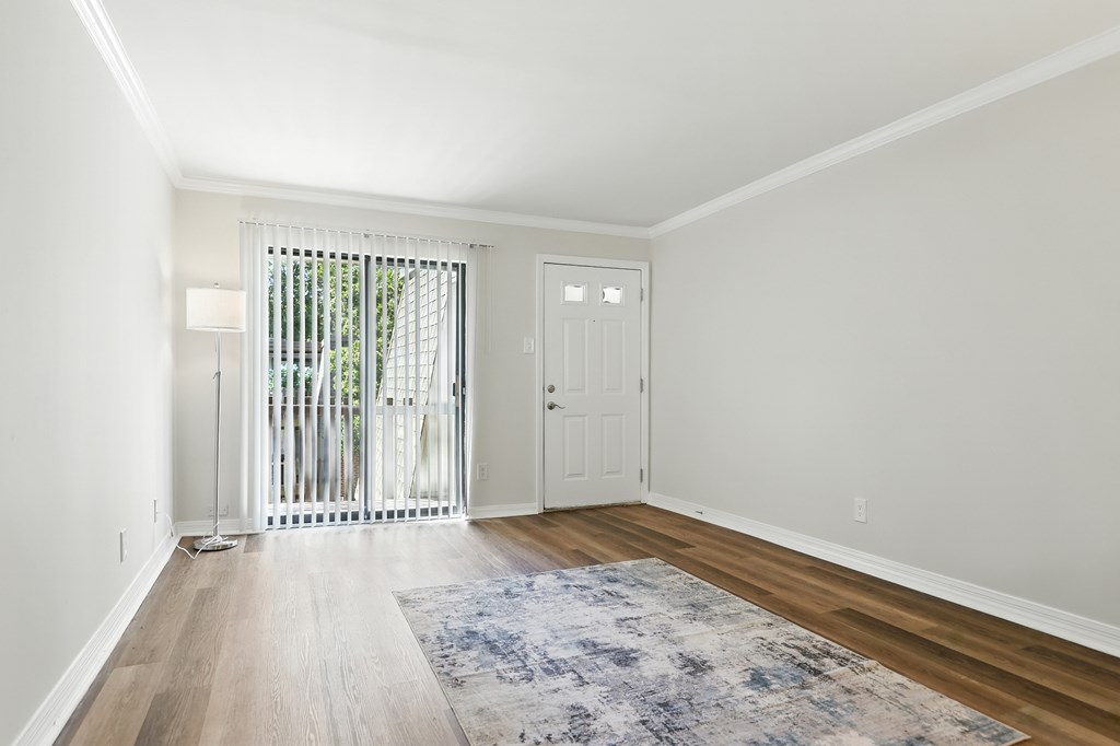 A room with a white door and a window with a white curtain.