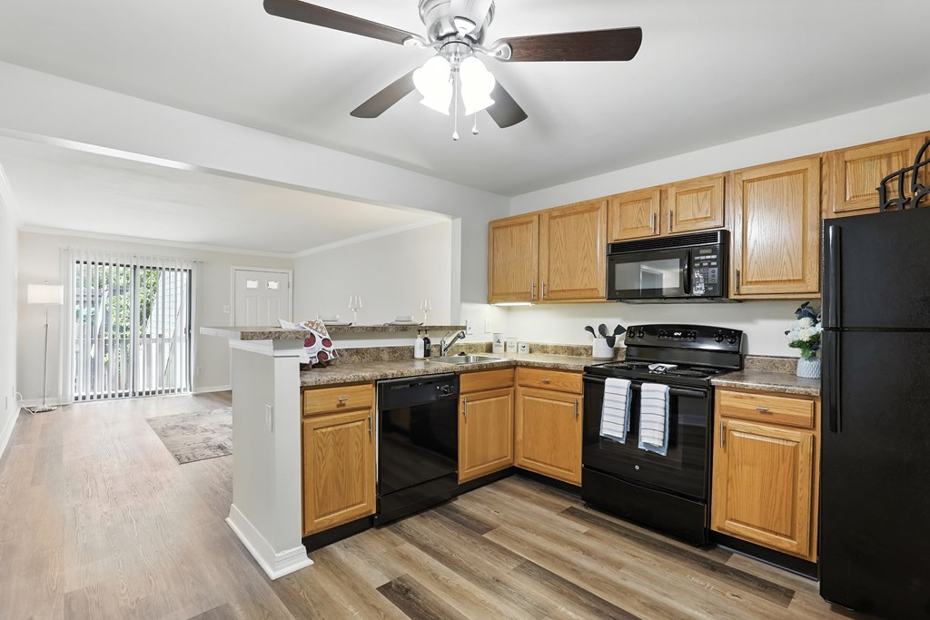 A kitchen with wooden cabinets and black appliances.