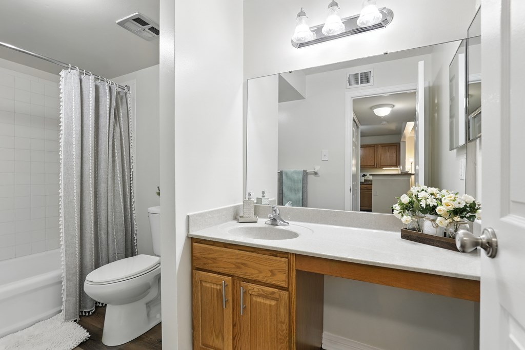 A white bathroom with a toilet, sink, and shower.