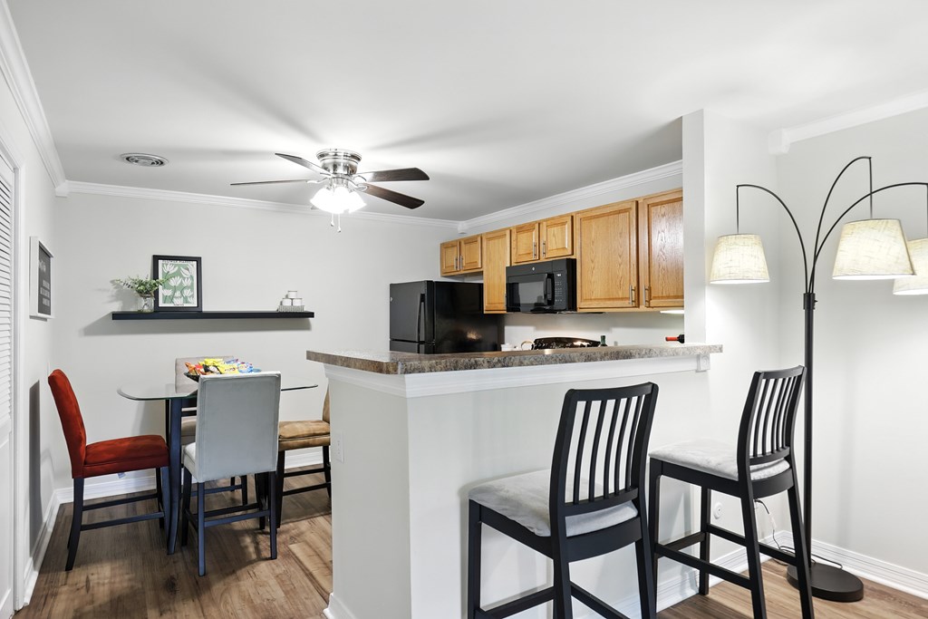 A kitchen with a table and chairs.