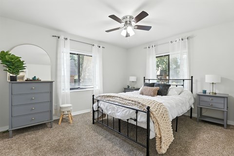 A bedroom with a bed, dresser, and window.