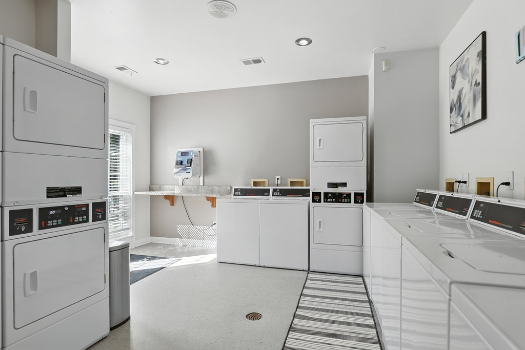 A row of white washing machines in a laundry room.