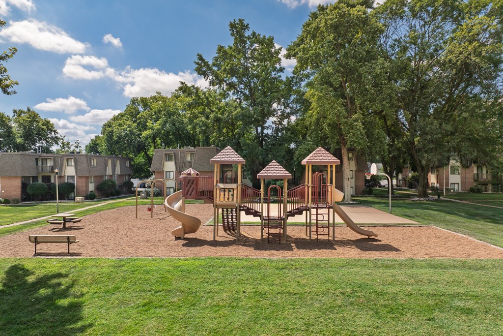 A playground with a slide, swings, and a sandbox.