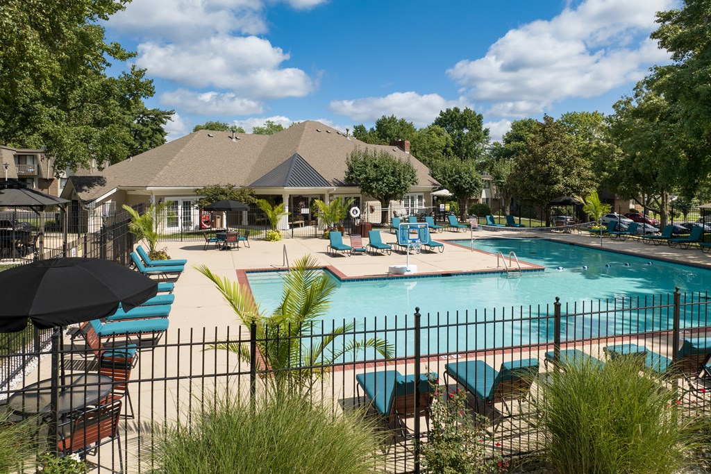 A pool area with a gazebo and lounge chairs.