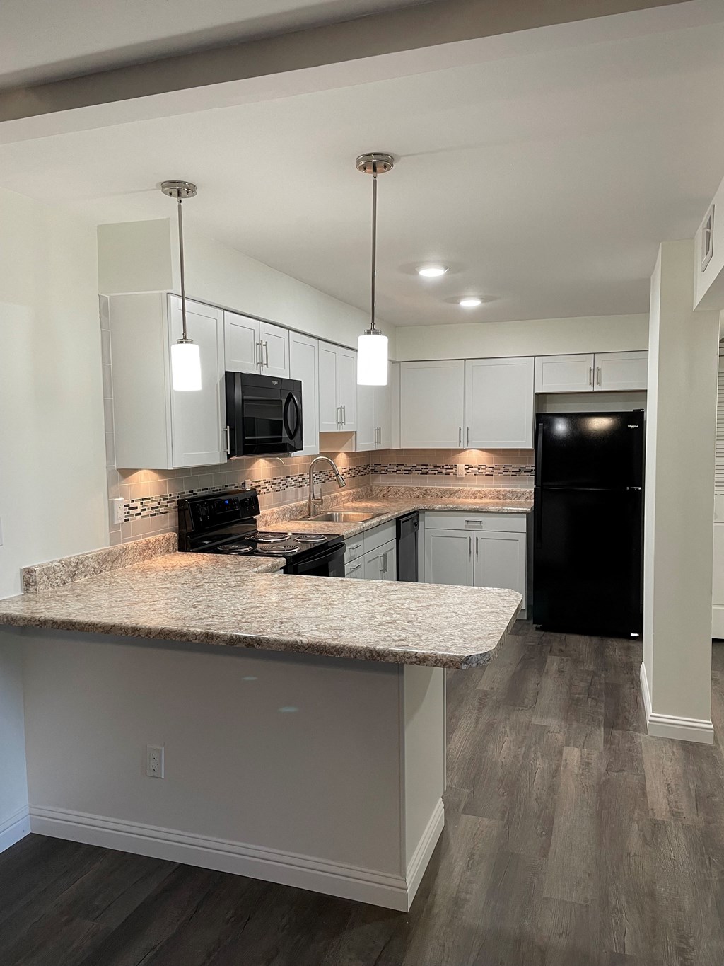 a kitchen with white cabinets and a granite counter top