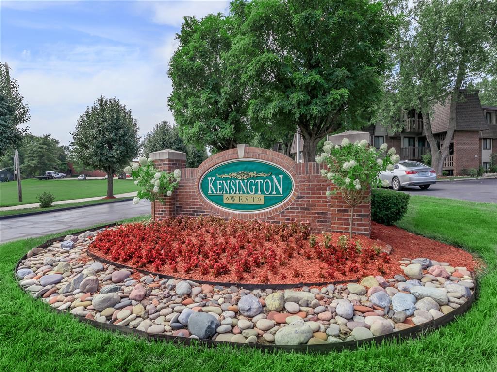 the sign estates in front of a stone retaining wall with red