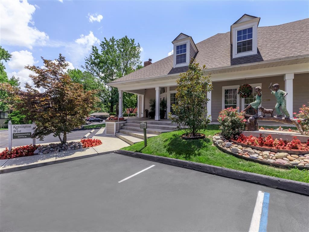 a house with a driveway and statues in front of it