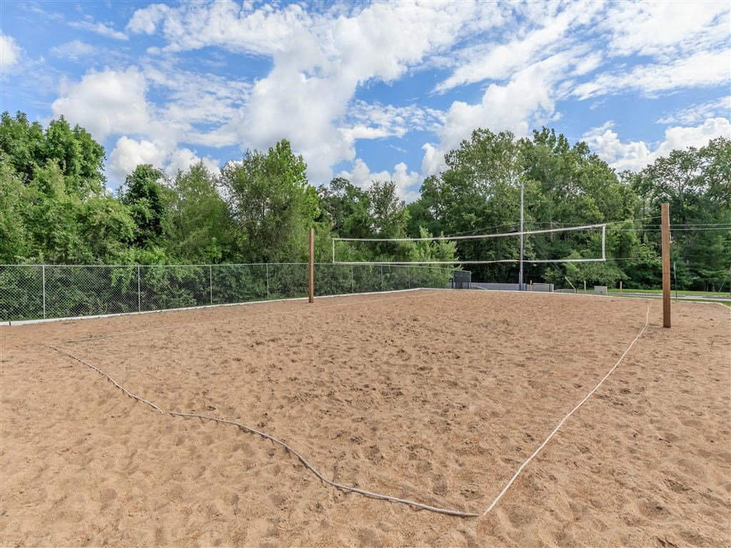 a volleyball court on a dirt field in front of trees