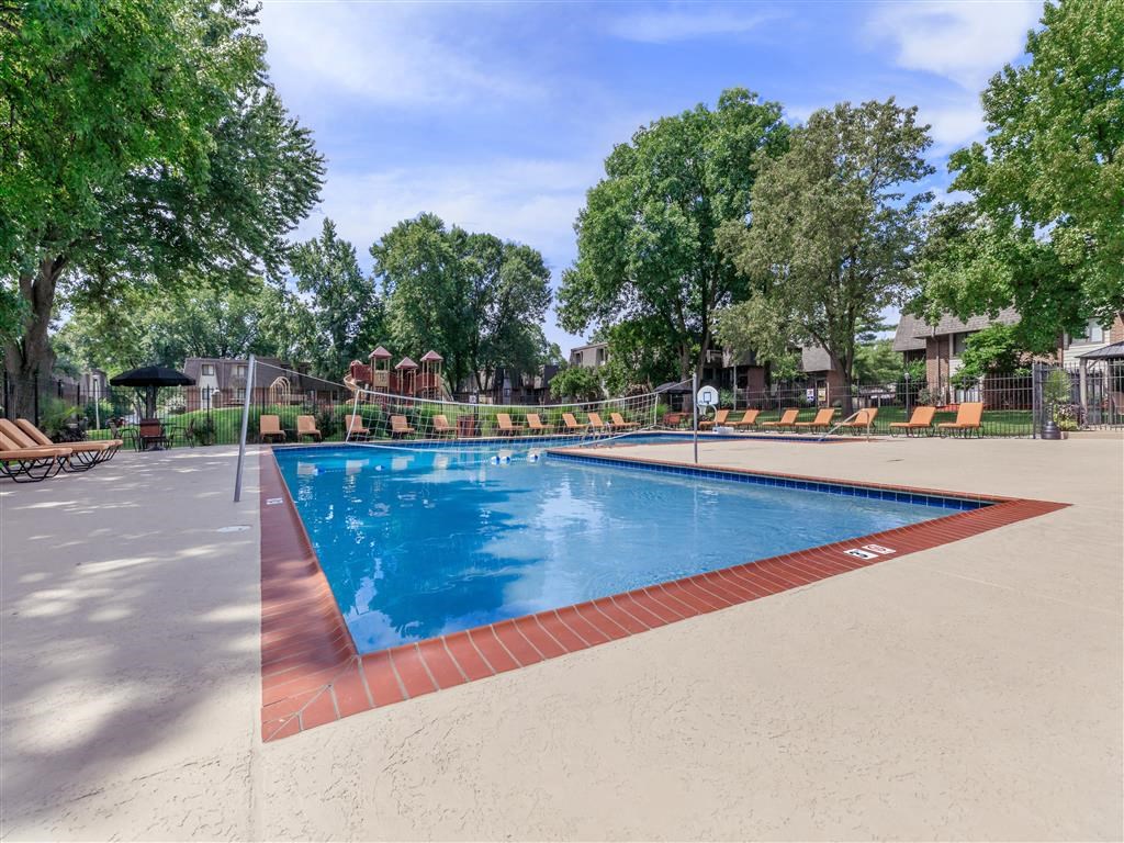 a swimming pool with trees and a fence around it