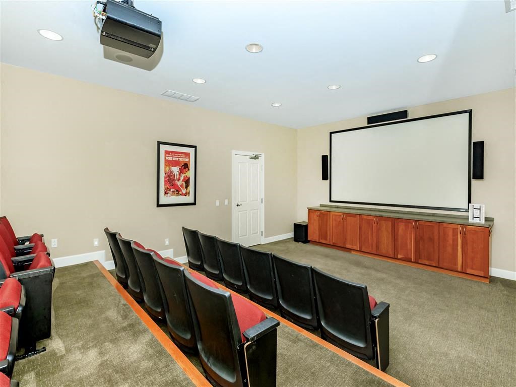 a theater room with a projector screen and chairs
