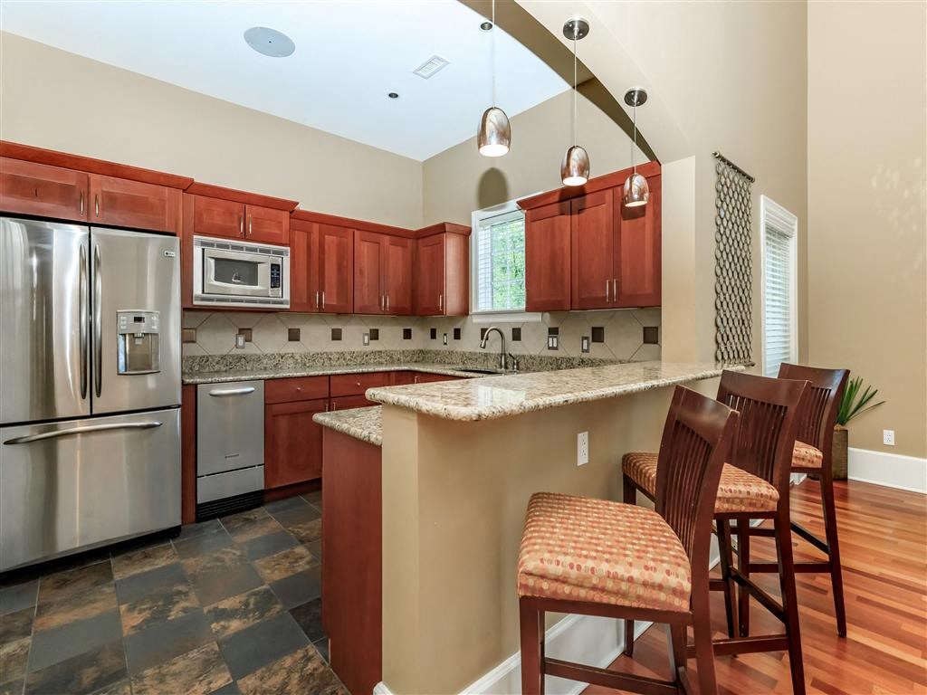 a kitchen with a bar and a stainless steel refrigerator